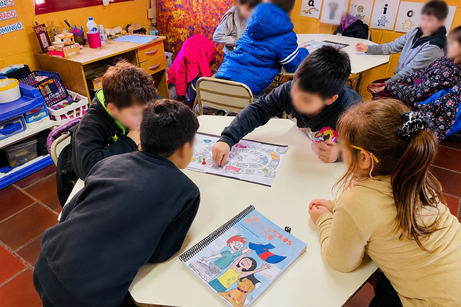 Chicos trabajando en grupo alrededor de la mesa con sus libros y lápices